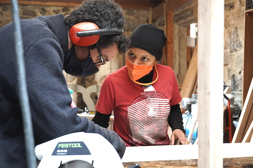 mentor Samuel Kalika demonstrates a cutting technique to student Pamela