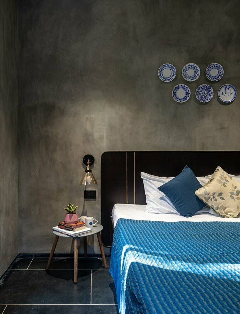 the bedrooms are low maintenance, with minimal storage, bright colors providing a contrast from the grey oxide walls, and feature in situ beds