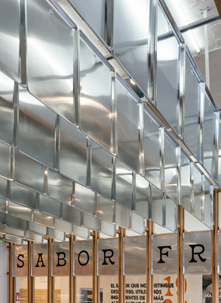 concèntrico envelops mi pan bakery with hanging metallic trays and pinewood in mexico