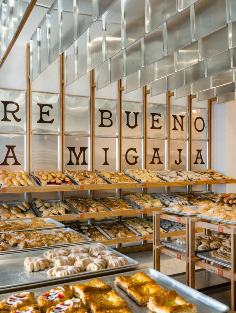 concèntrico envelops mi pan bakery with hanging metallic trays and pinewood in mexico