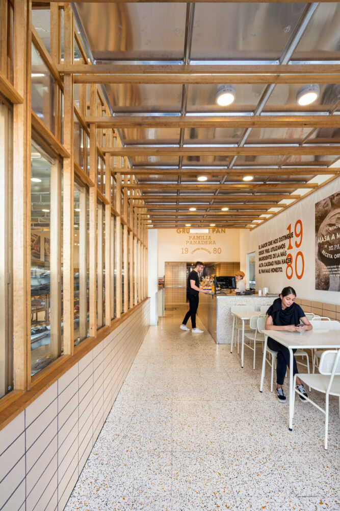concèntrico envelops mi pan bakery with hanging metallic trays and pinewood in mexico