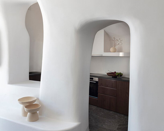 kapsimalis architects’ summer house in santorini emerges from a cliffside cave