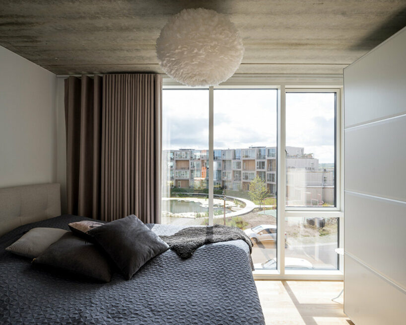 BIG’s modular housing spirals around central pond in danish sustainable suburb