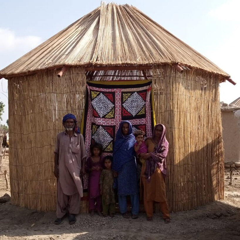 a flood-hit family posing by its shelter | image courtesy of INTBAU Pakistan