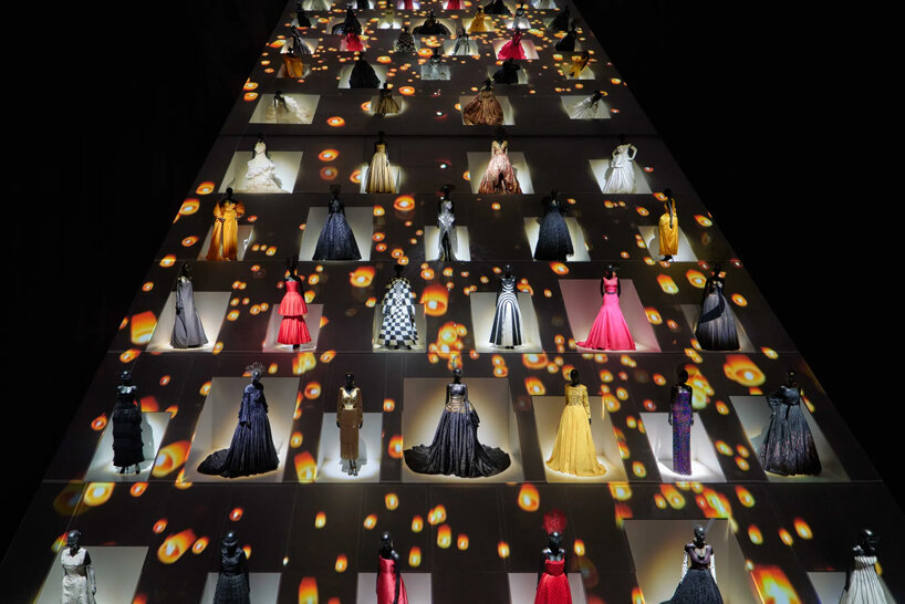 mannequins in gowns climb up a giant slope in OMA-designed dior exhibition in tokyo