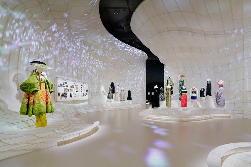 mannequins in gowns climb up a giant slope in OMA-designed dior exhibition in tokyo