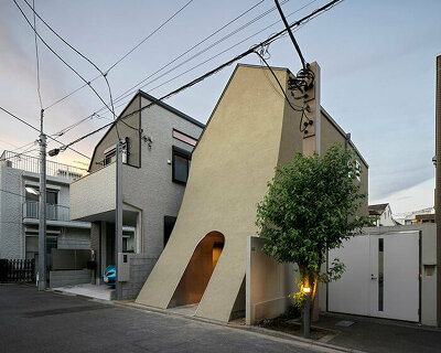 a sweeping introverted facade shelters artist's split-leveled home studio in tokyo