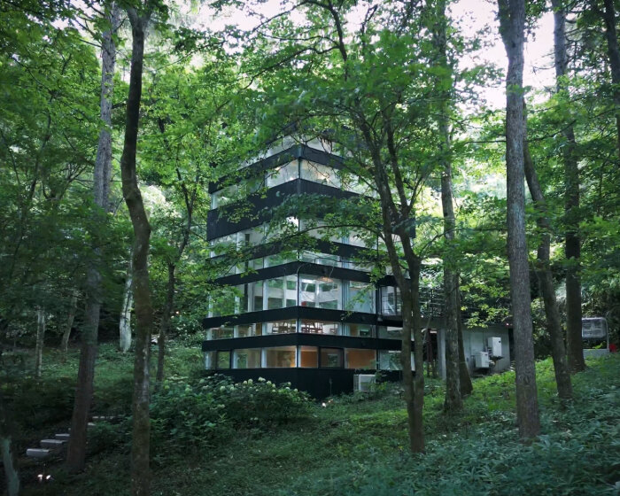 hiding glass house in japanese forest sees 360 degrees through all-round windows