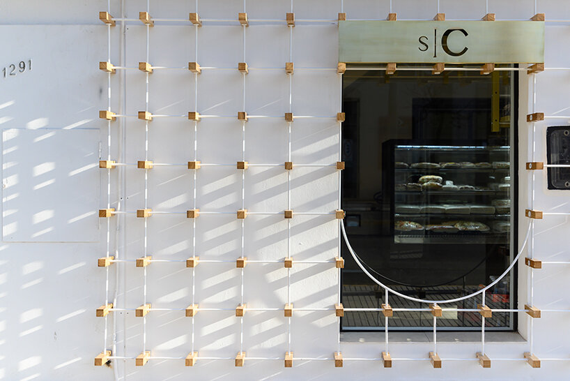 EFEEME arquitectos uplifts bakery façade in argentina with smooth iron and wooden props