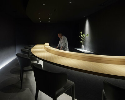 black-ink walls and dim lighting engulf this members-only sushi restaurant in tokyo