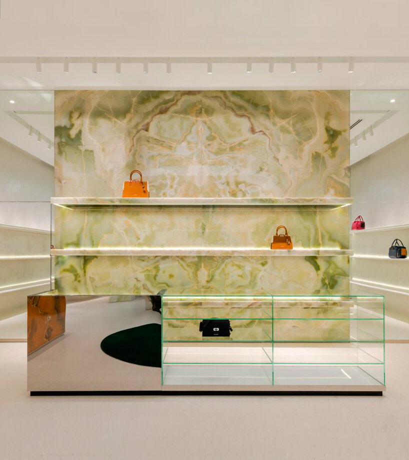 the serene green onyx feature wall sits at the end of the store accompanied by a glass display counter