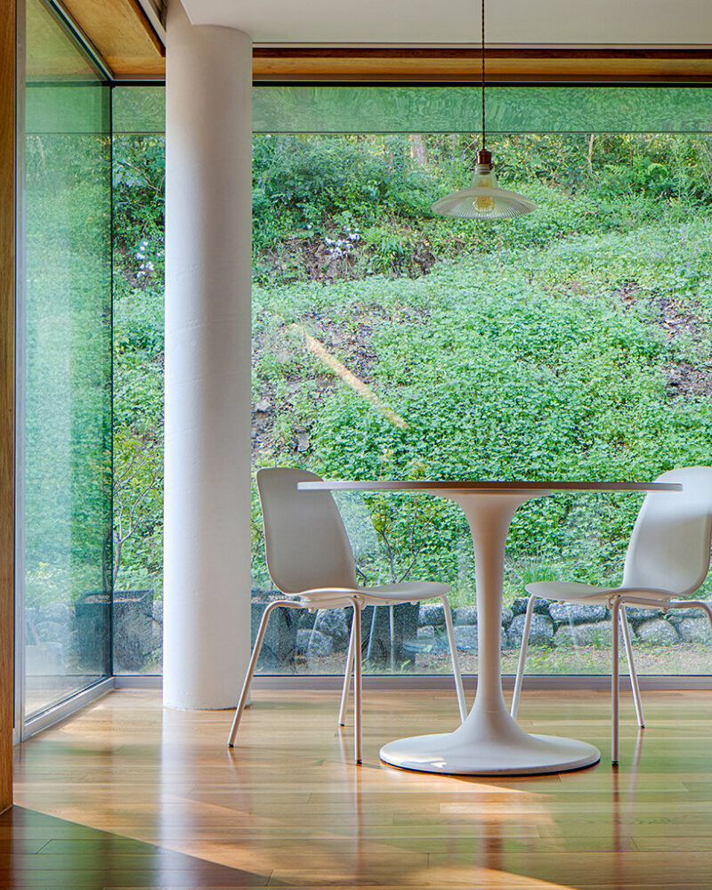 a minimalist retreat is nestled beneath the wooded mountains of korea