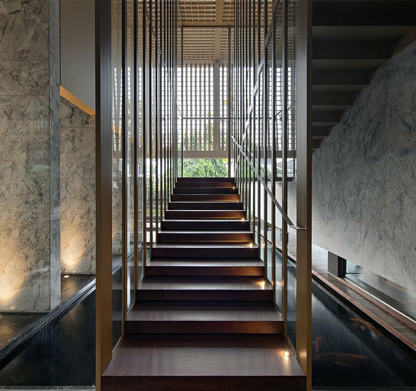 the floating staircase hovers above the koi pond and forms a commodious middle stair landing serving as a seating step