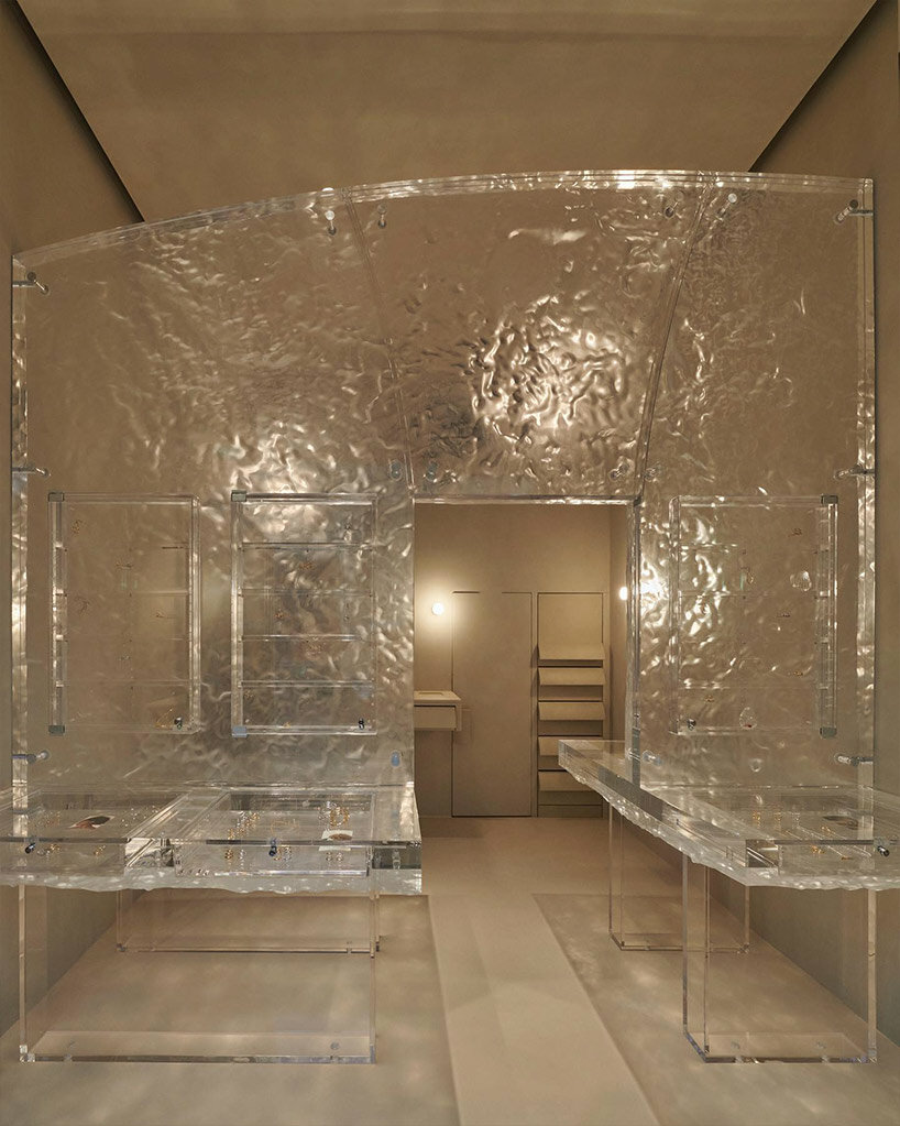 fine jewelry collection floats within monolithic translucent wall in parisian boutique