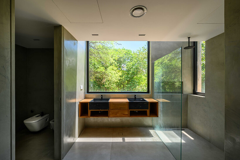 floating in argentina’s forests, this ‘LS house’ is flooded with patterned shadows