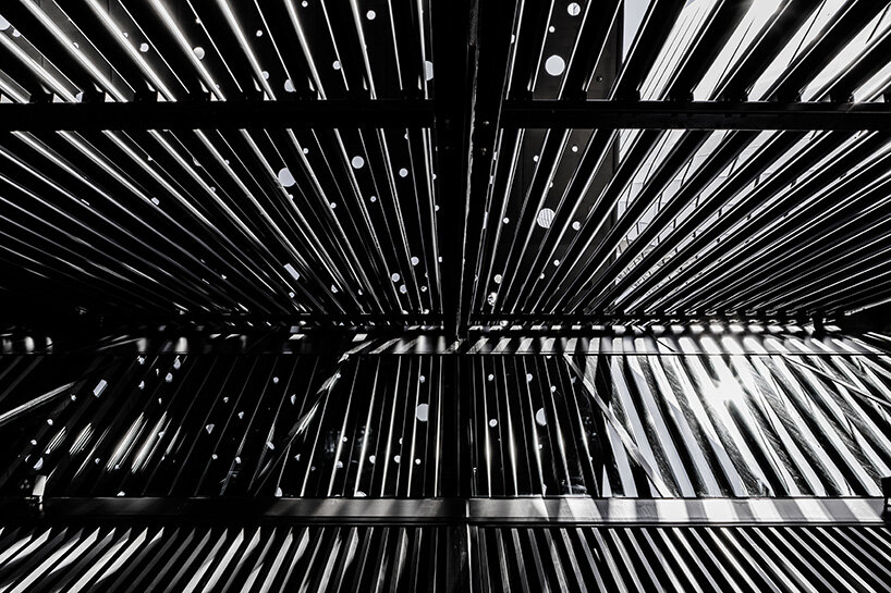 the pitched roof is formed by a rhythmic utilitarian steel screen