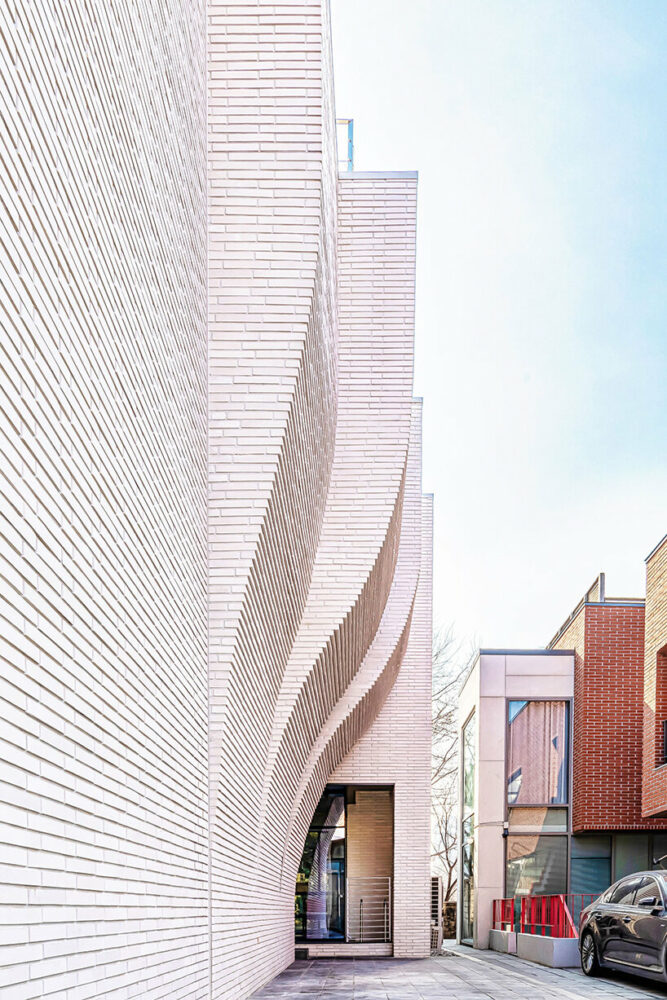 a curved brick wall ripples across LESS architects’ office building design in seoul
