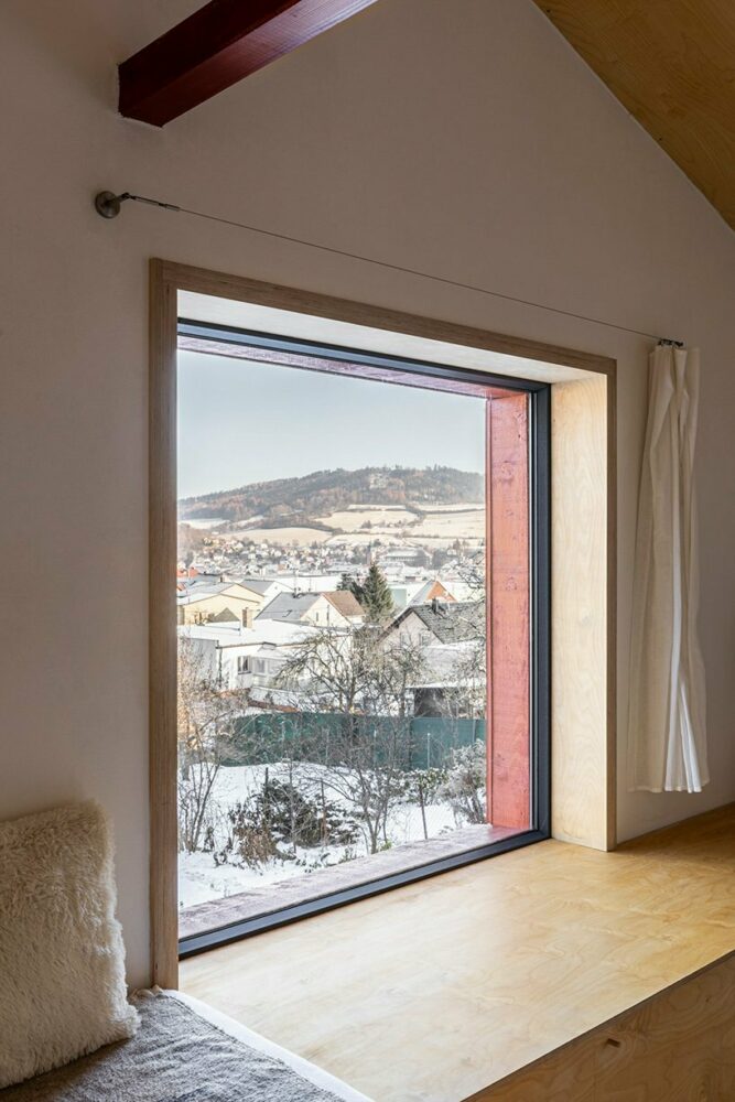 the sitting area overlooks the town and nearby countryside through a large window
