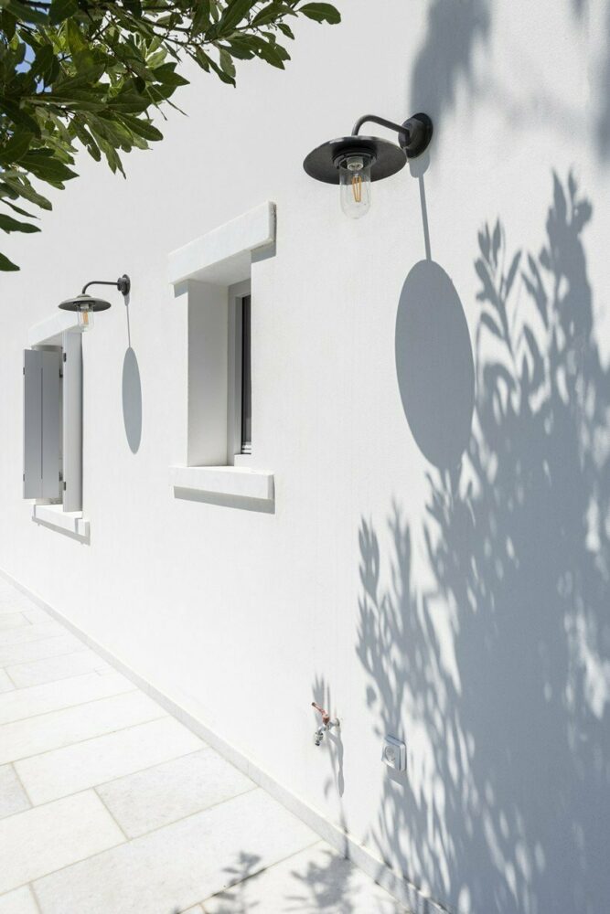 marble inlays adorn spolia house’s pure white facade in greek island