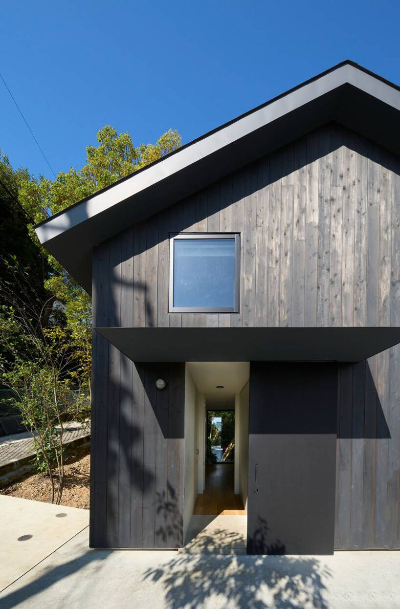 airhouse's wooden home floats above a steep slope in the japanese forest 