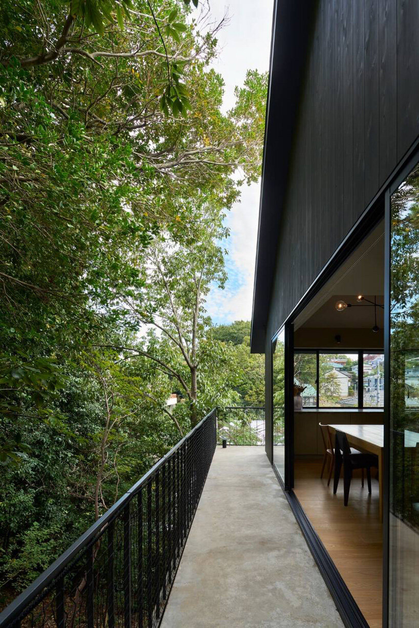 airhouse's wooden home floats above a steep slope in the japanese forest 