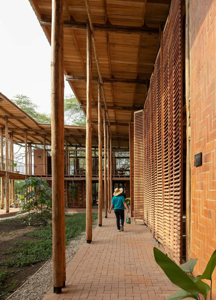 round teak wooden posts uphold natura futura’s community center in ecuador