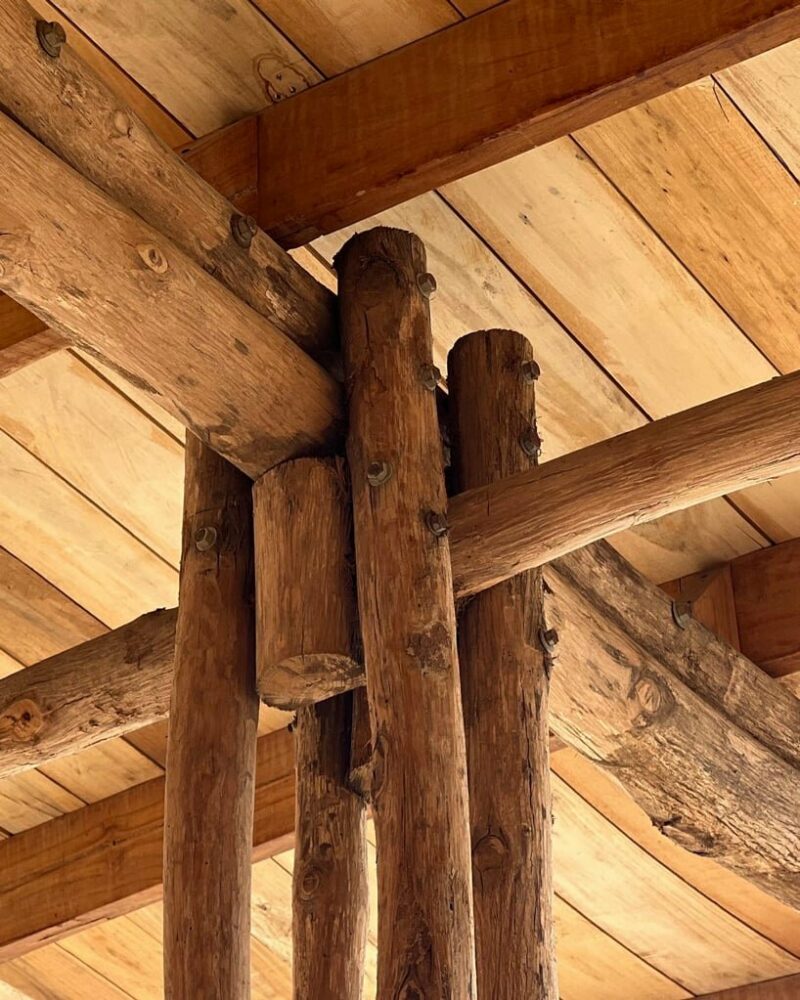 round teak wooden posts uphold natura futura’s community center in ecuador