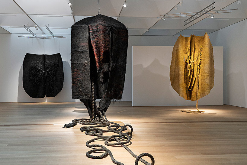 woven biomorphic sculptures by magdalena abakanowicz hover inside MCBA, switzerland

