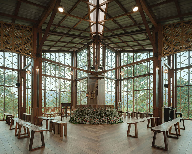 intricate timber latticework envelops st francis oratory amidst thailand’s serene landscapes