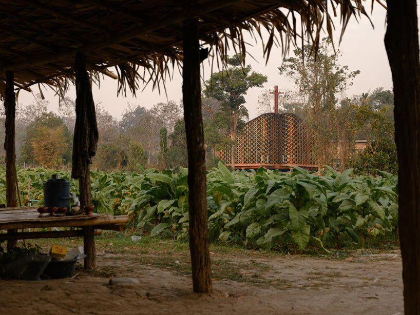 intricate timber latticework envelops st francis oratory amidst thailand’s serene landscapes