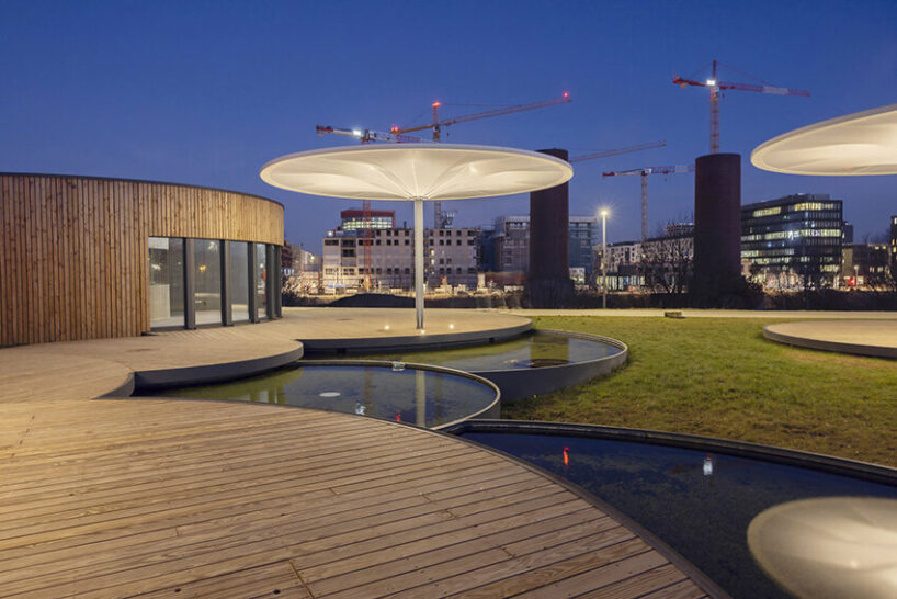 bebunch’s wooden pavilions, ponds, and umbrella canopies weave through public park