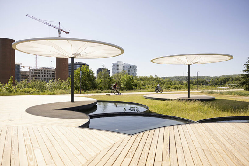 bebunch’s wooden pavilions, ponds, and umbrella canopies weave through public park