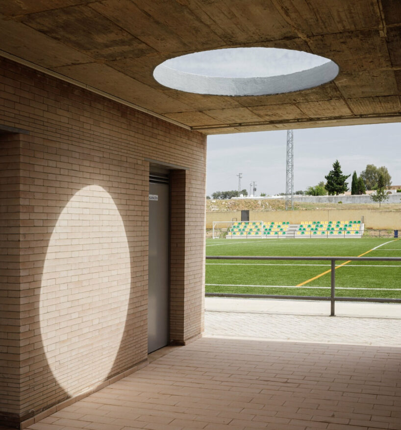 Vestuario alargado revestido de ladrillo completa un pequeño campo de fútbol en Sevilla