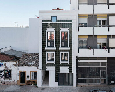 corpo atelier adheres tiled facade and window frame fragments to building in portugal