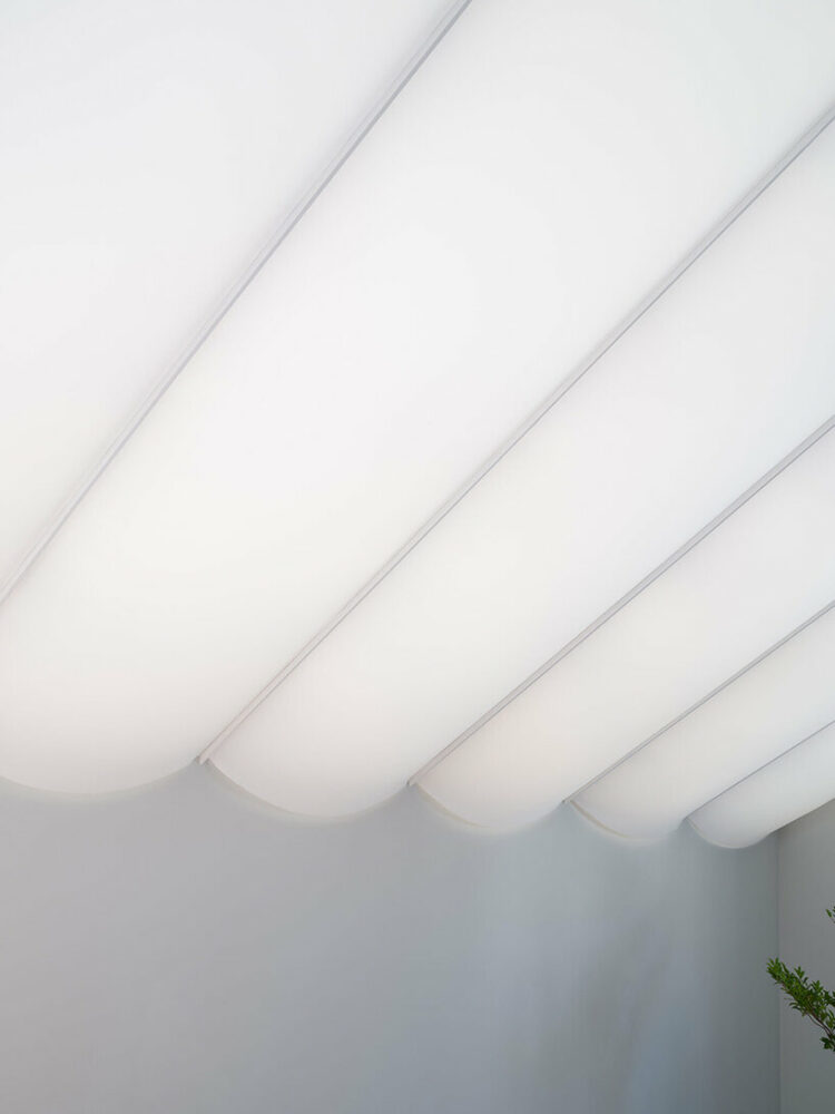 tubular membrane roof casts a soft glow over this two-story house in tokyo