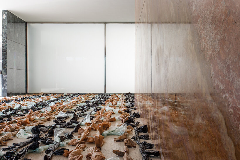 endless plastic bags fill mies van der rohe’s barcelona pavilion to spotlight the cost of money