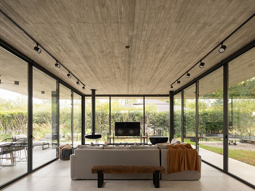 thin reinforced concrete sheet hovers above the glazed living room of house jp in argentina
