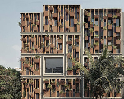 shared workspaces in india are wrapped in a living facade of stone planters