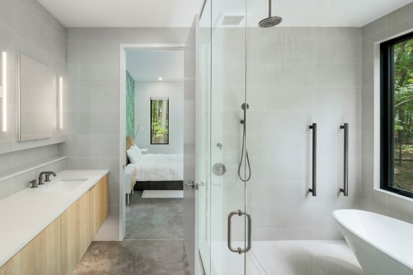 monochrome wood-clad house by studio mm nestles along sloped site in upstate new york