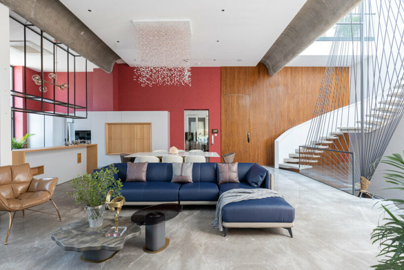 the kitchen is located next to the dining area, accompanied by a vibrant red accent wall that adds a bold touch of color