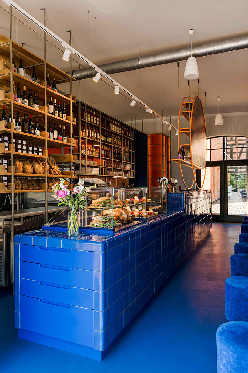 cobalt blue and warm orange tones pair up inside poland's pastry club woda - 3