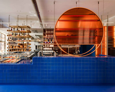 cobalt blue and warm orange tones pair up inside poland's pastry club woda