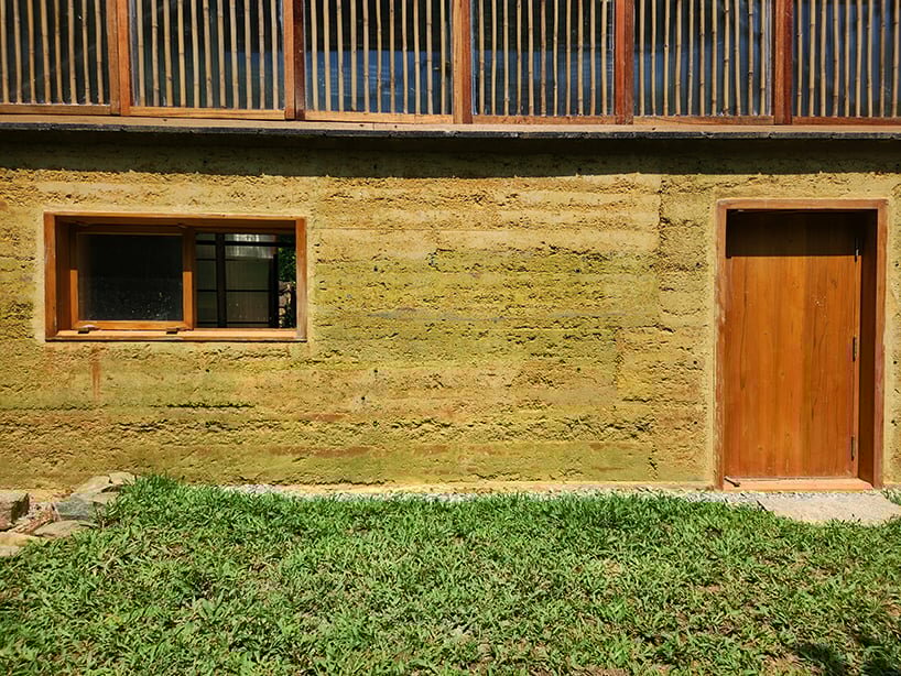 the newly rebuilt rammed earth wall applies soil and earth reused from the site