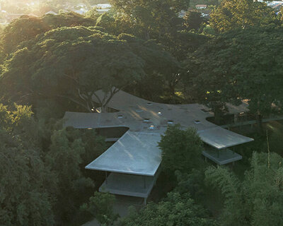 all(zone) joins five curved wings to compose 'under the rain trees' house in northern thailand