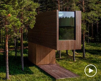 arsenit's prefabricated treehouse suspends over a terrace in the estonian wilderness
