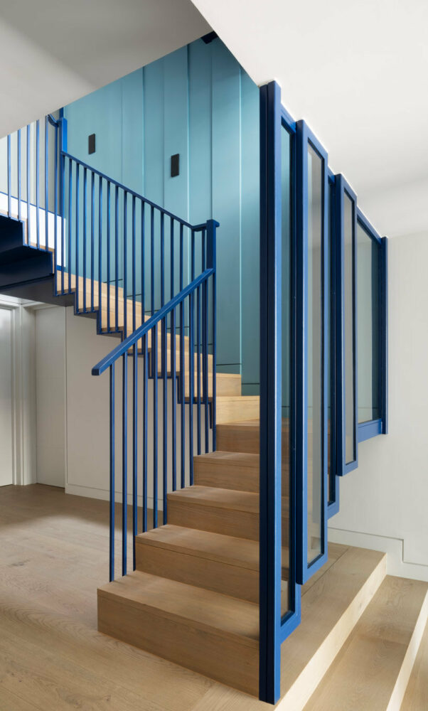 a suspended staircase in a vibrant azure blue connect all floors