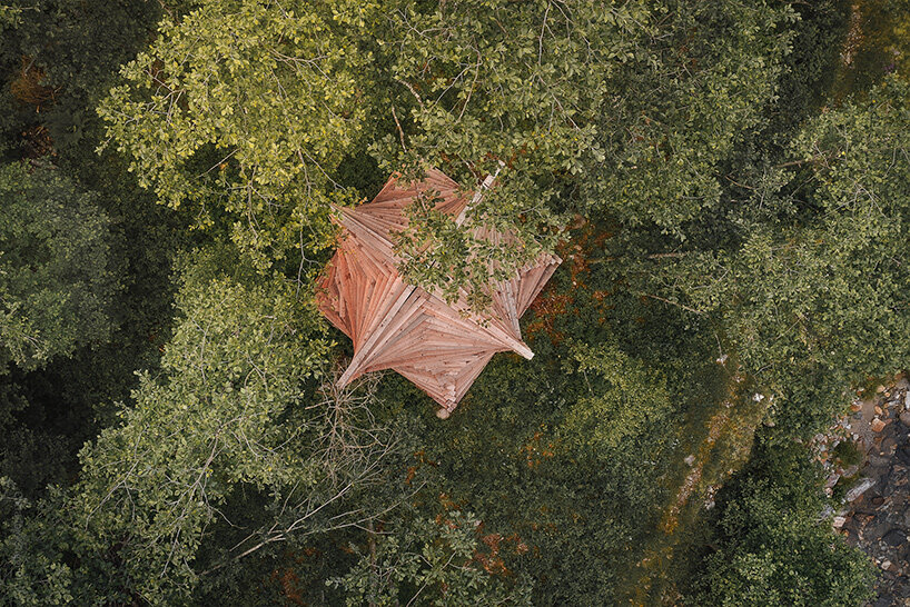 davide macullo's interwoven timber pavilions nestle in the swiss alps woodland 