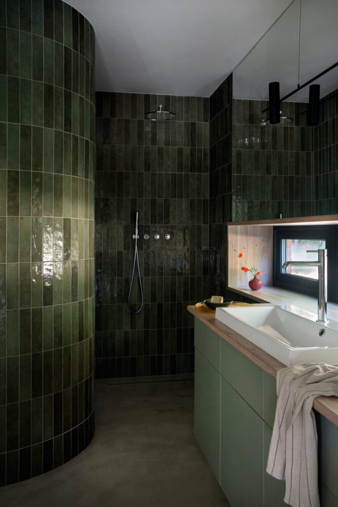 the bathroom uses the same ceramic tiles as the kitchen