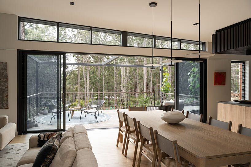 large sliding doors open the living area onto a sunlit deck