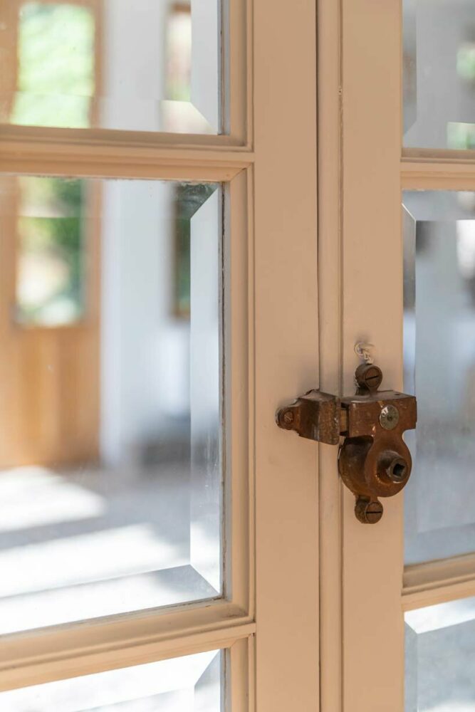 the lock detail on a glass door serves as a testament to the history of the house